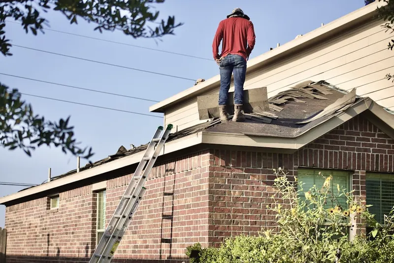 Professional roofer working on a residential roof in Lindenhurst